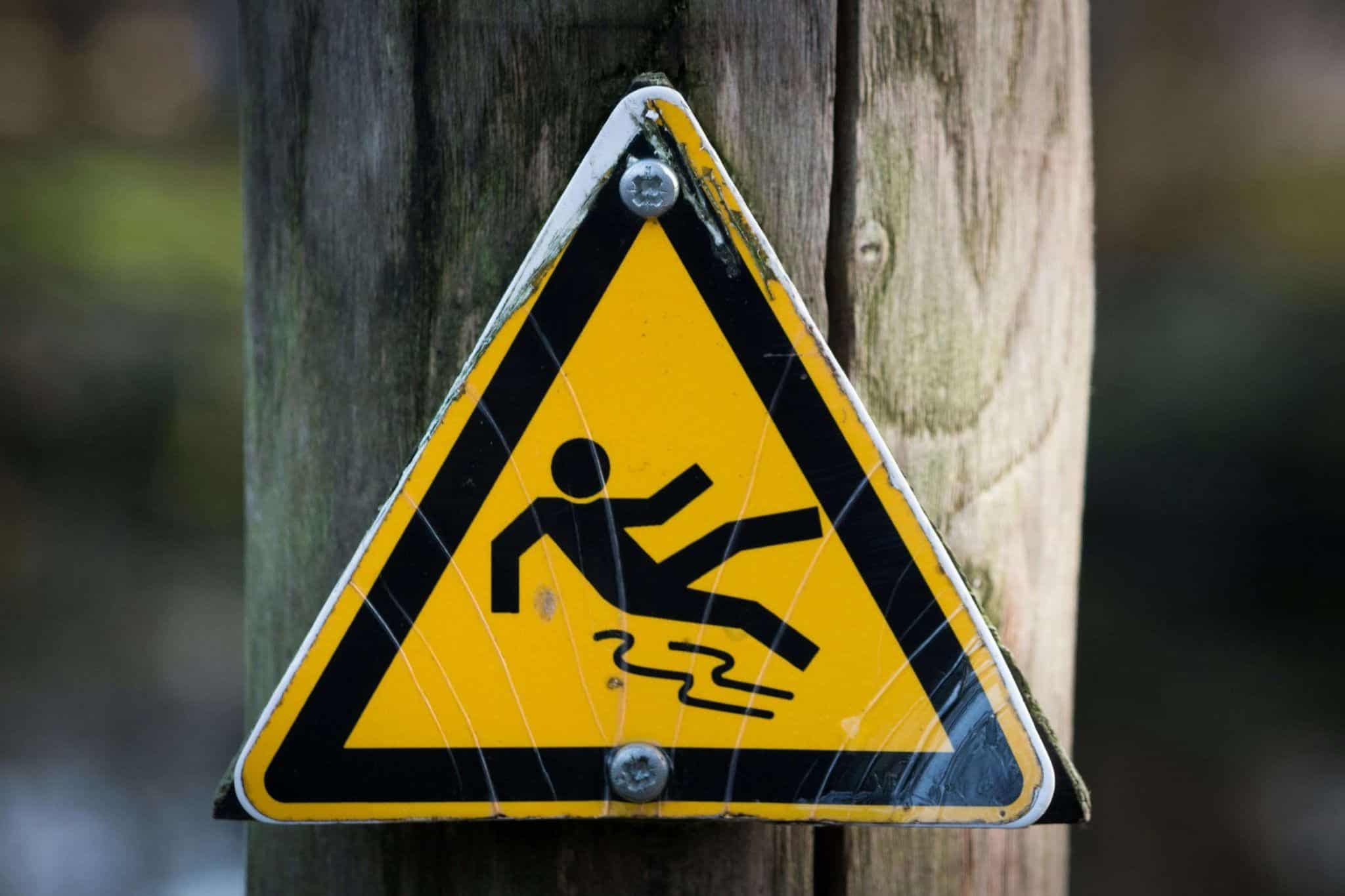 Warning sign showing a slipping hazard, representing wet floors and slip and fall accident risks